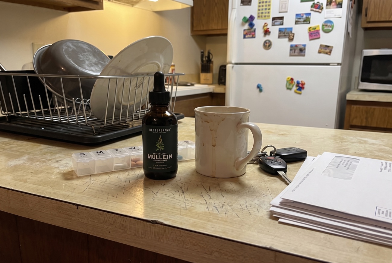 The BetterLungs tincture on a kitchen counter beside a pill organiser